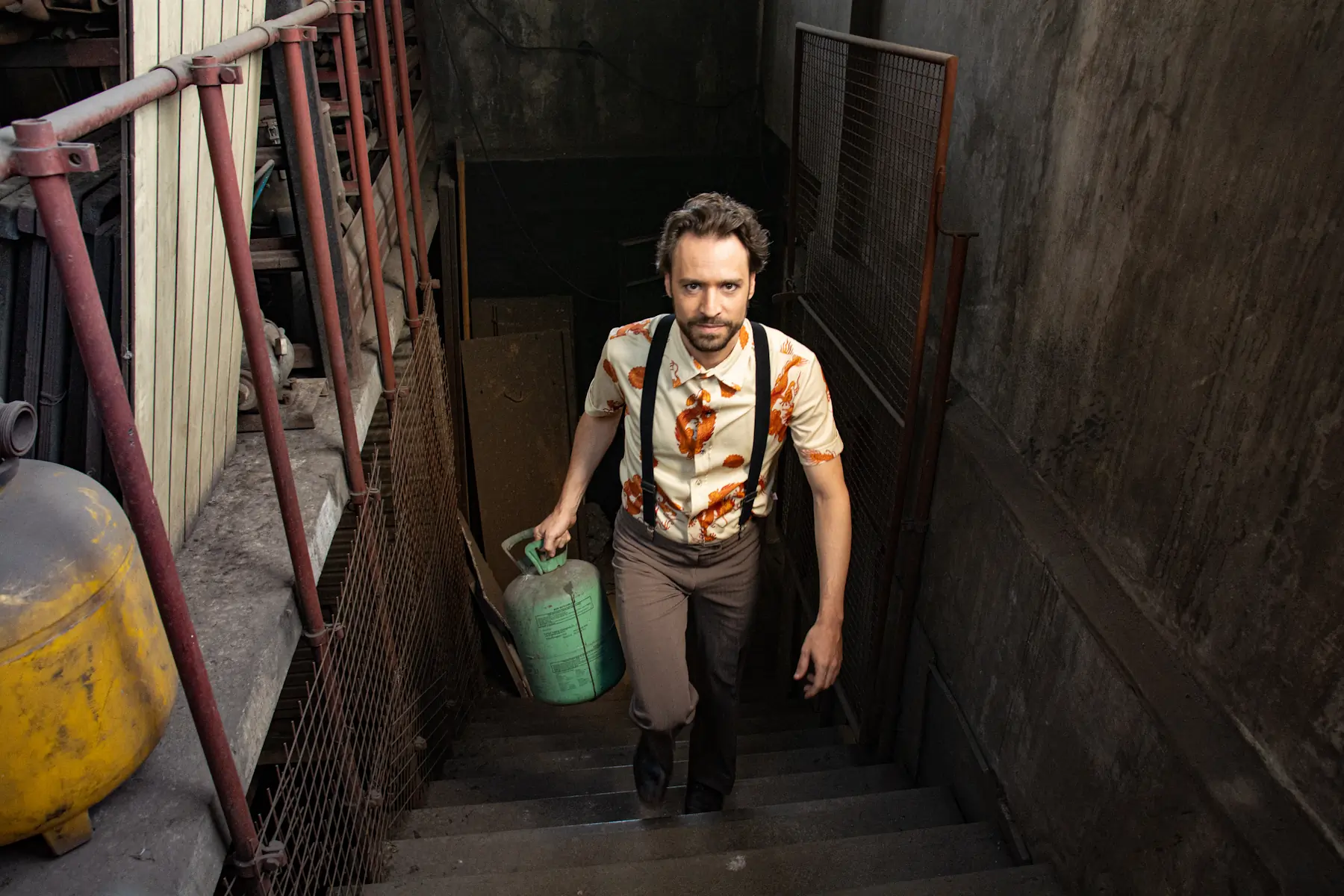 Juan Wolcoff subiendo por una escalera con una garrafa en su mano