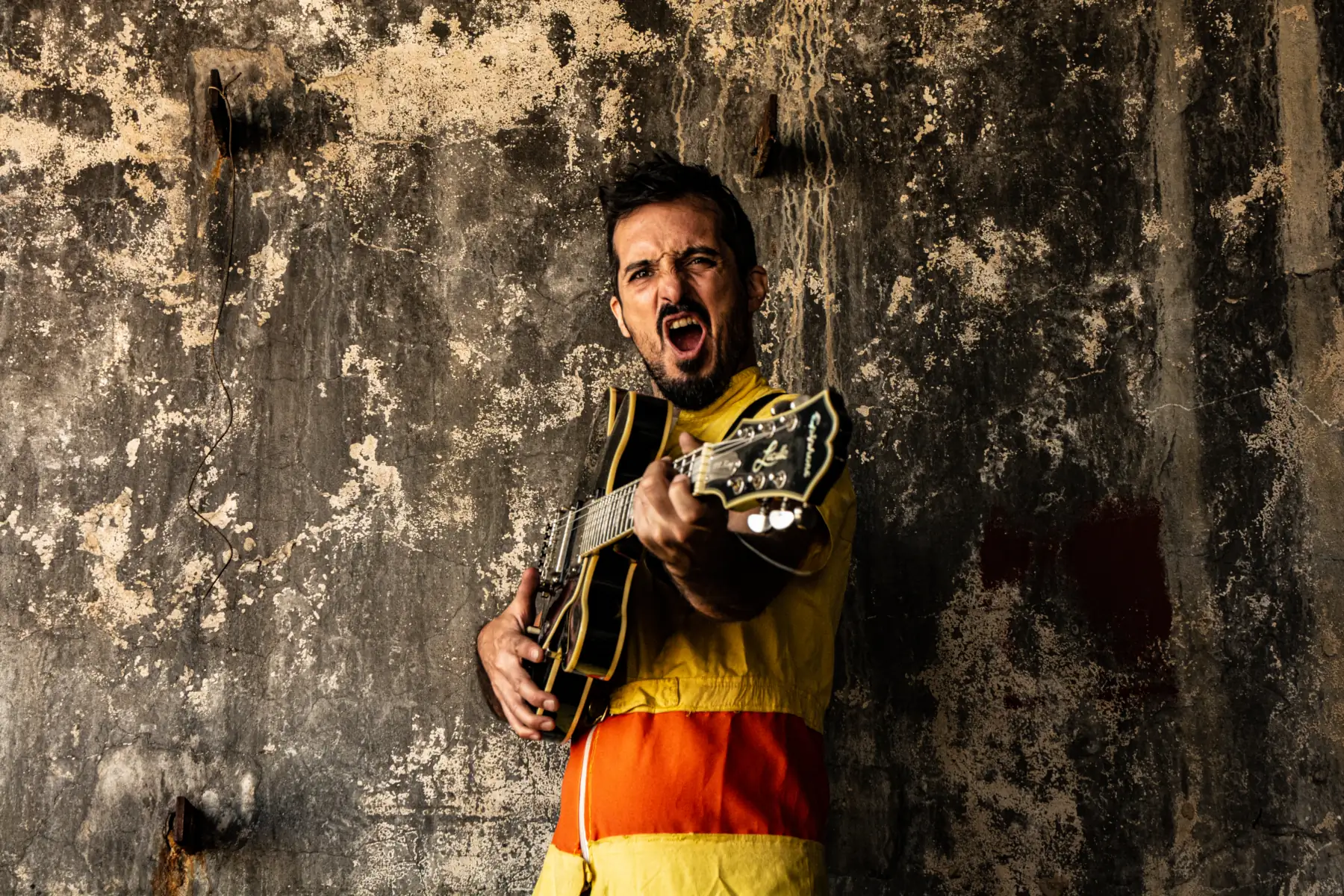 Tomás Rodriguez músico de la bomba de humo impro, con su guitarra en brazos