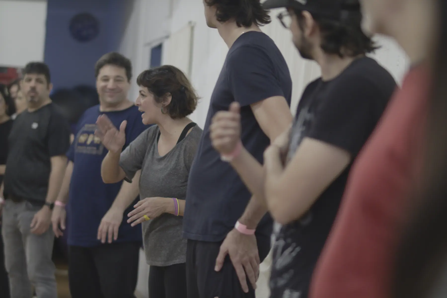 un grupo de personas en un escenario realizando un entrenamiento de improvisation teatral / a group of people on a stage performing improvisational theater training