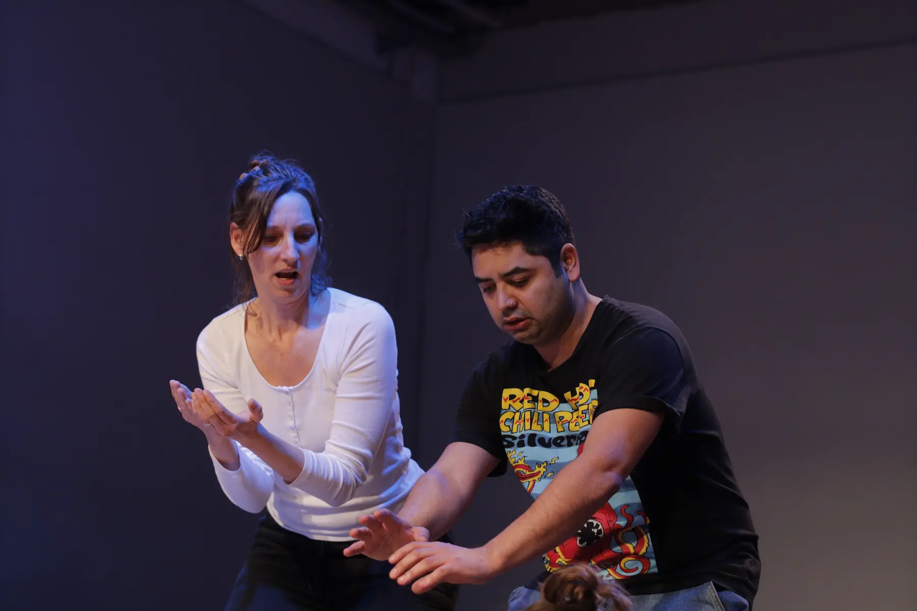 un hombre y una mujer en un escenario realizando una escena teatral improvisada