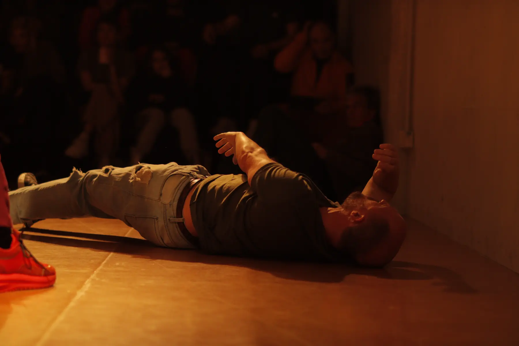 Escena de improvisaci贸n teatral con un actor en el suelo, interpretando un momento dram谩tico