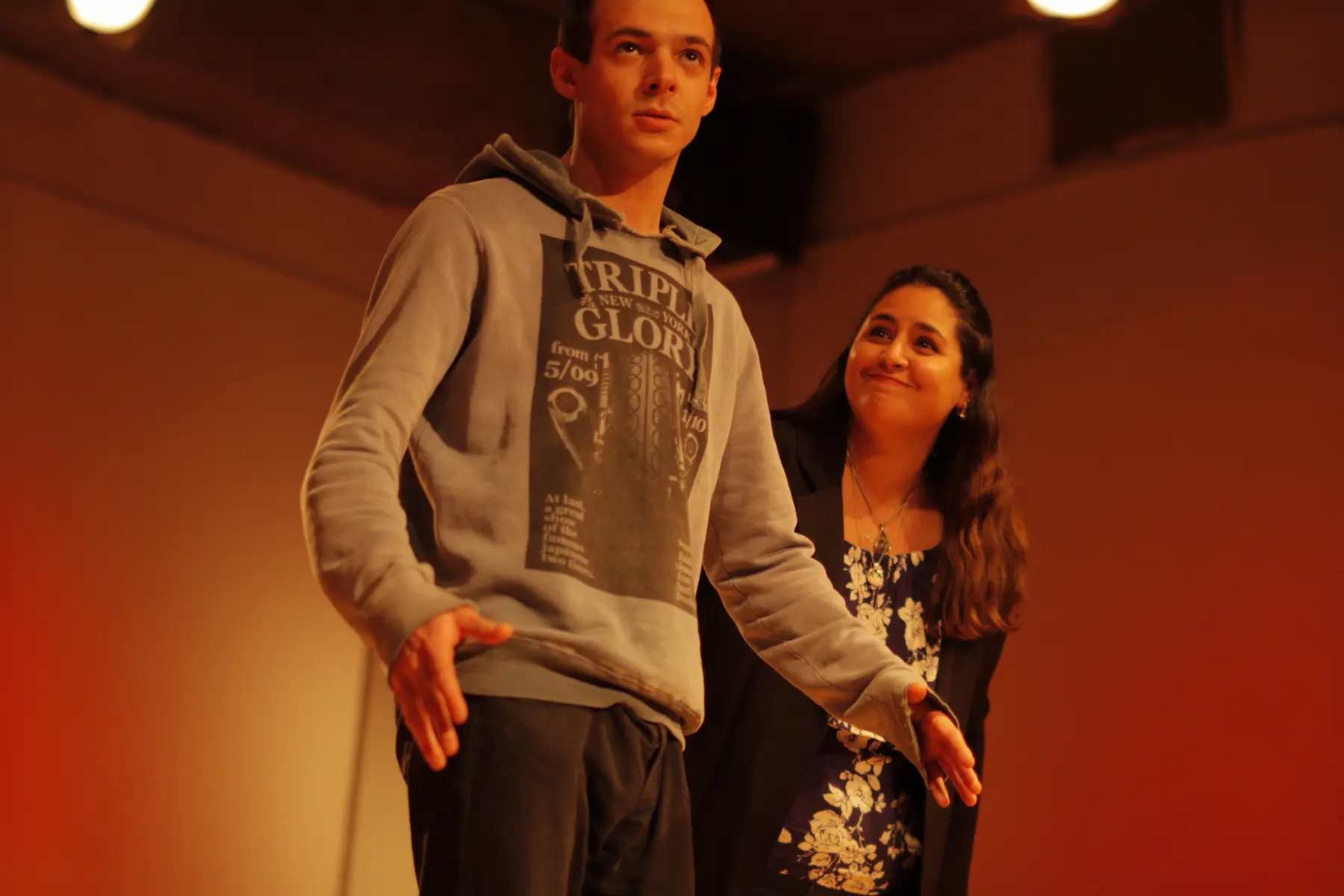 un hombre y una mujer en un escenario realizando una escena teatral improvisada