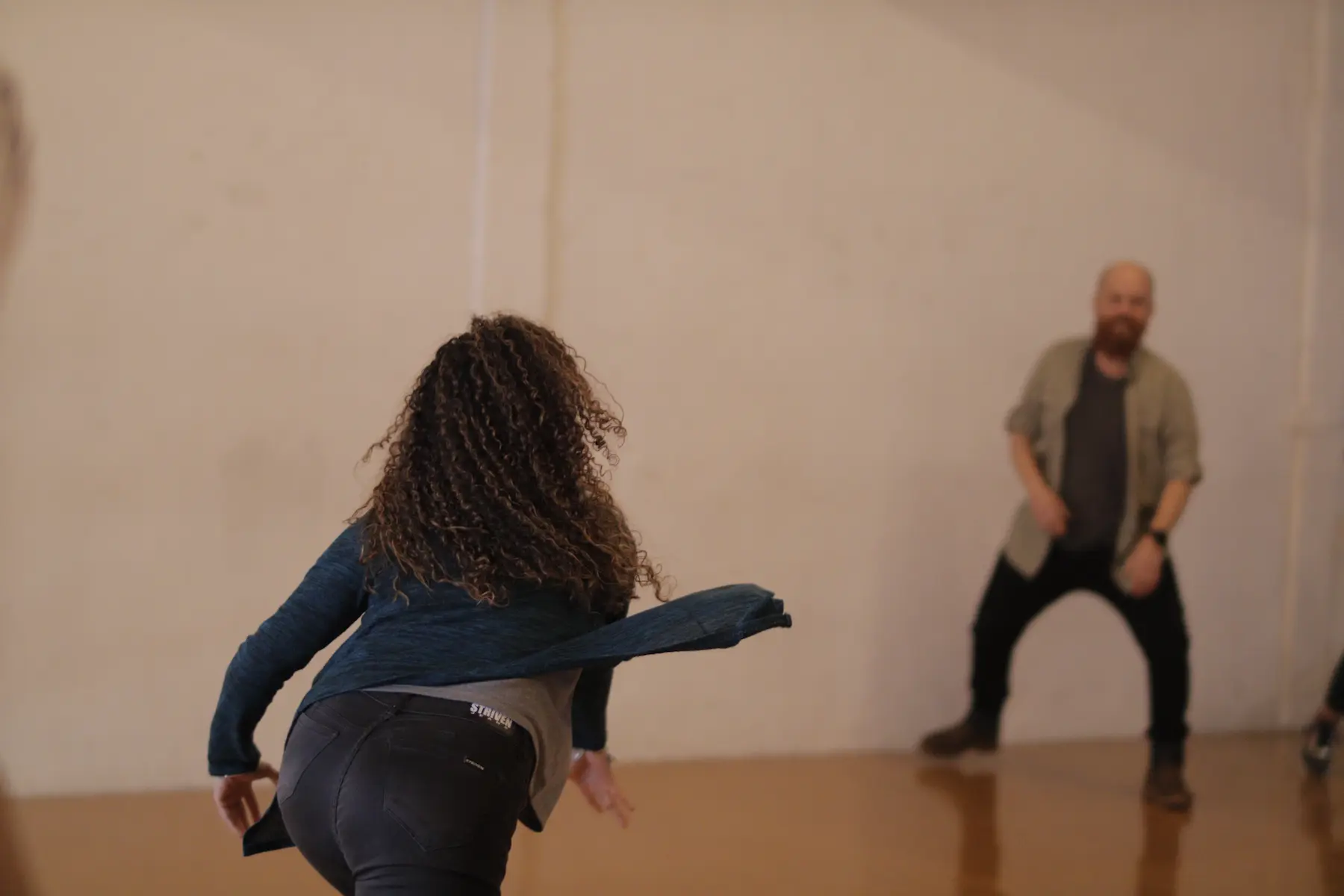 En un ambiente de entrenamiento teatral, una mujer entre un grupo de personas que la acompañan