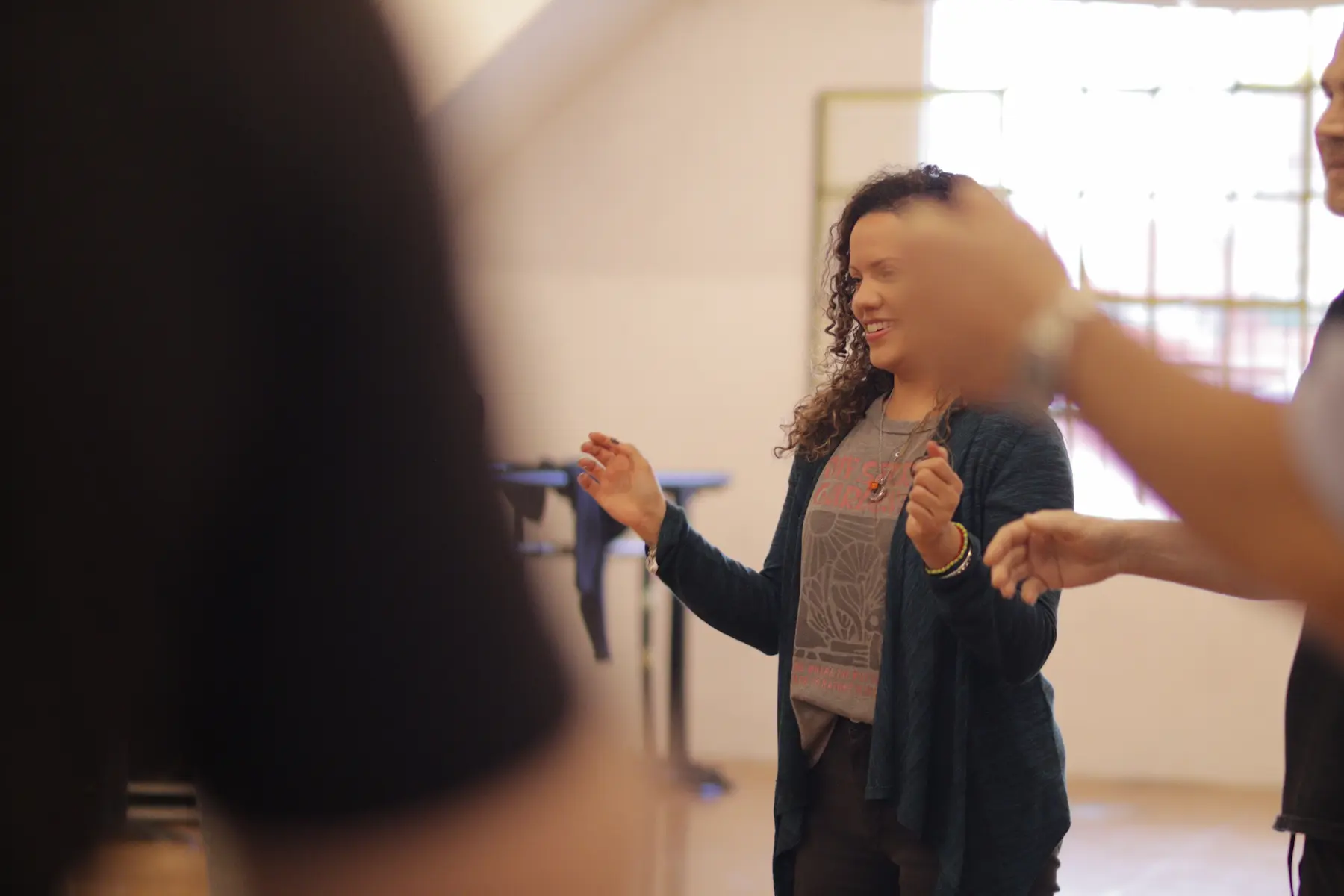 Grupo de personas juntos en una sala, disfrutando de un momento de calentamiento teatral