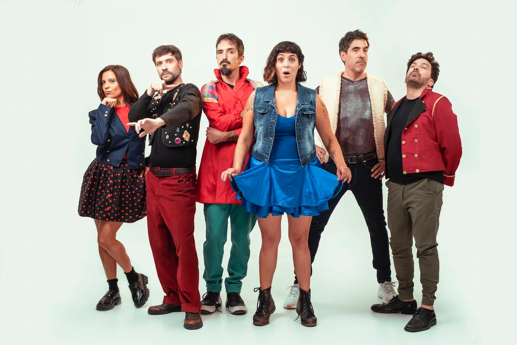 Elenco de "La Bomba de Humo Impro" posando con vestuario teatral colorido y expresiones lúdicas sobre fondo claro.